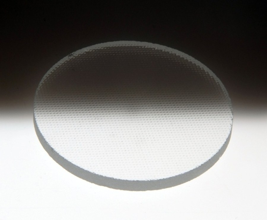 A round disc of Solite glass showing the fine stippled texture pressed into one surface.